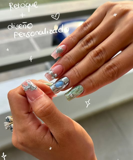 Uñas largas con diseño cromado y detalles plateados